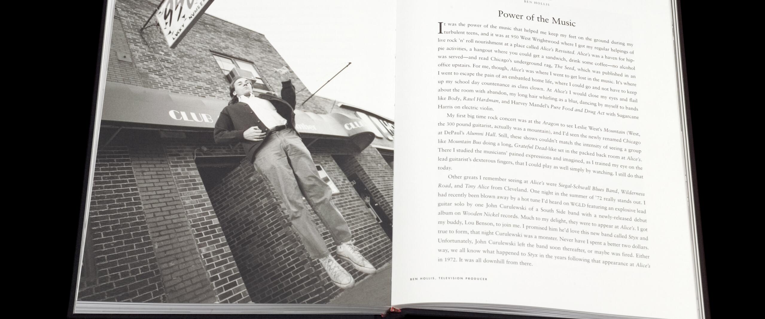 Open book with a black-and-white photograph on the left page showing a person standing casually outside a brick building with a sign above. The right page has an essay titled "Power of the Music" by Ben Hollis.