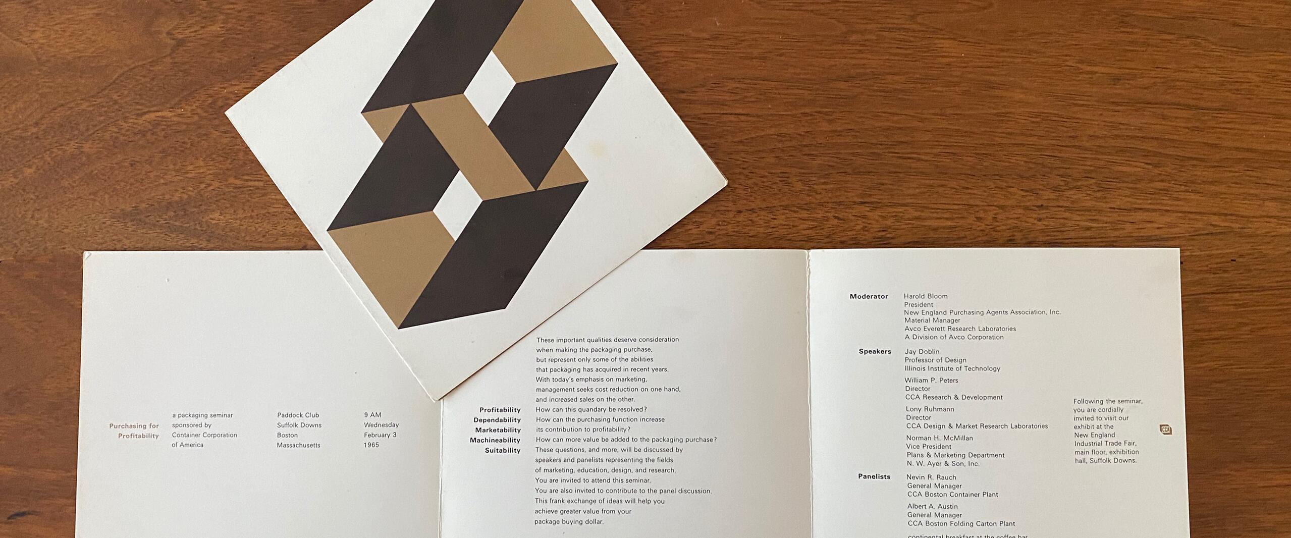 Open brochure on wooden table with geometric art print on top. Brochure displays event information and names in black text on white background. Geometric art features interlocking shapes in black and brown.