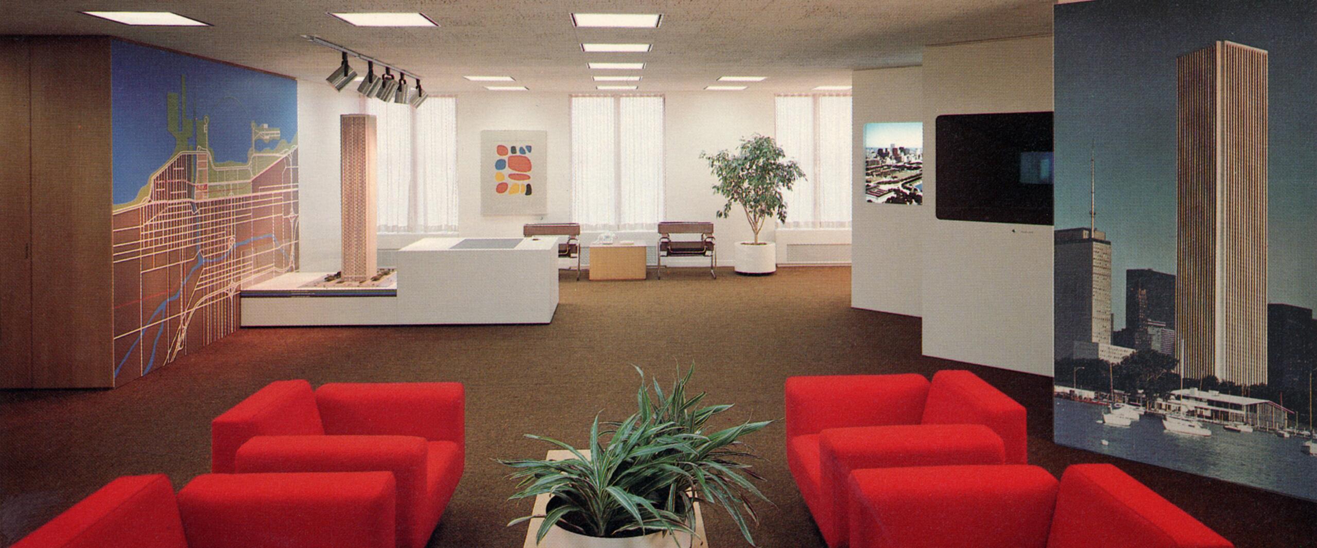Modern office with red chairs, a central table with a plant, and large architectural displays. Walls are decorated with a city map and a tall building image. Soft lighting and a potted tree add to the ambiance.