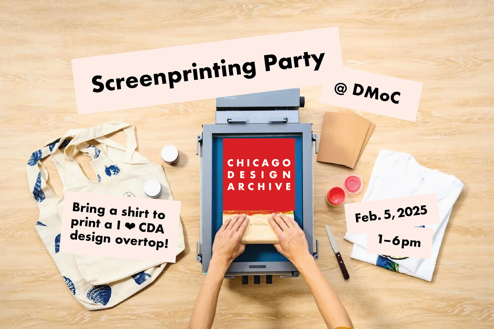 Hands screen printing a red "Chicago Design Archive" poster on a blue background. Nearby are a printed tote bag, a folded shirt, envelopes, ink jars, and a squeegee, all on a wooden table.