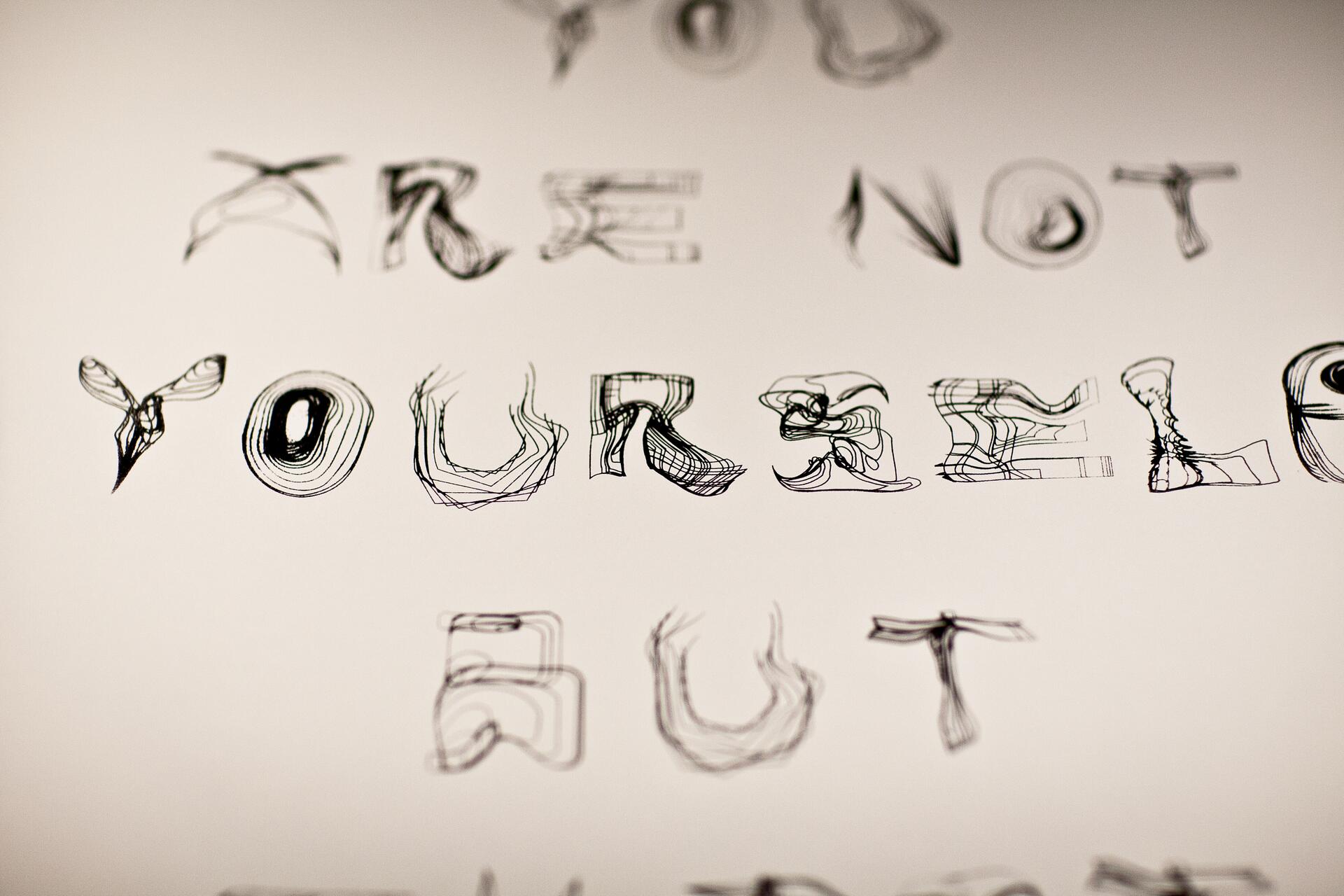 Distorted text in various fonts on a light background, forming an abstract artistic pattern.