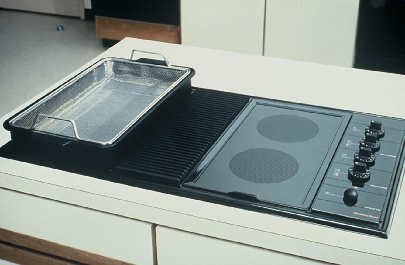 Electric stovetop with two burners, control knobs on the right, and a rectangular grill pan on the left.