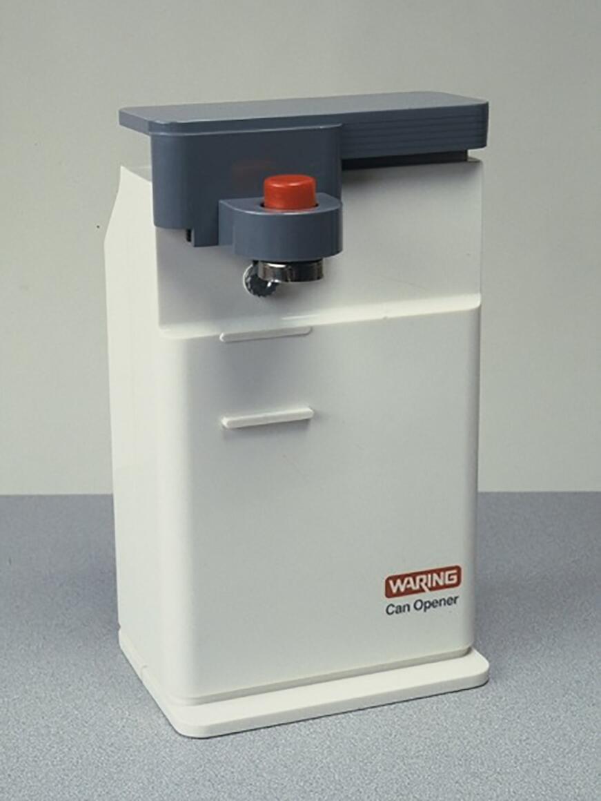 Electric can opener with a white body, gray top, and a red button, placed on a gray surface.