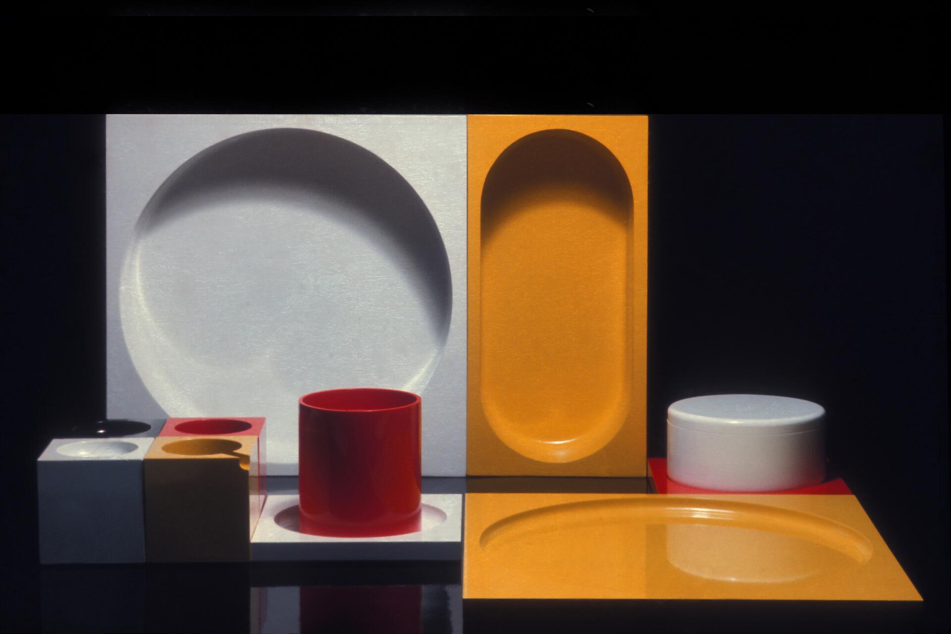 Abstract composition with geometric shapes in white, yellow, red, and black. Includes cylinders, rectangles, and concave forms arranged against a dark background.