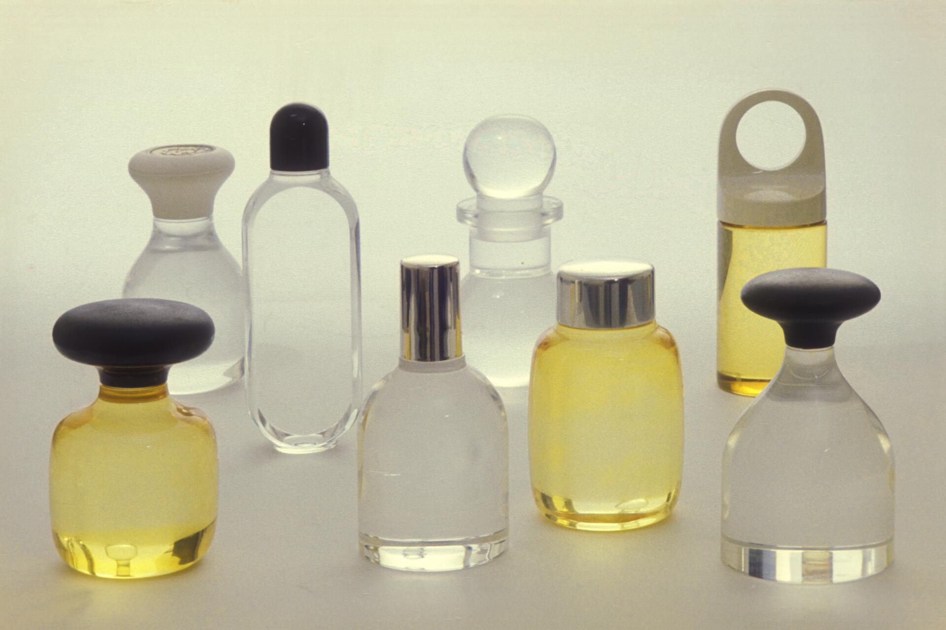 Various bottles and jars of different shapes and sizes containing clear and yellow liquids, with a minimalist and modern design on a light background.