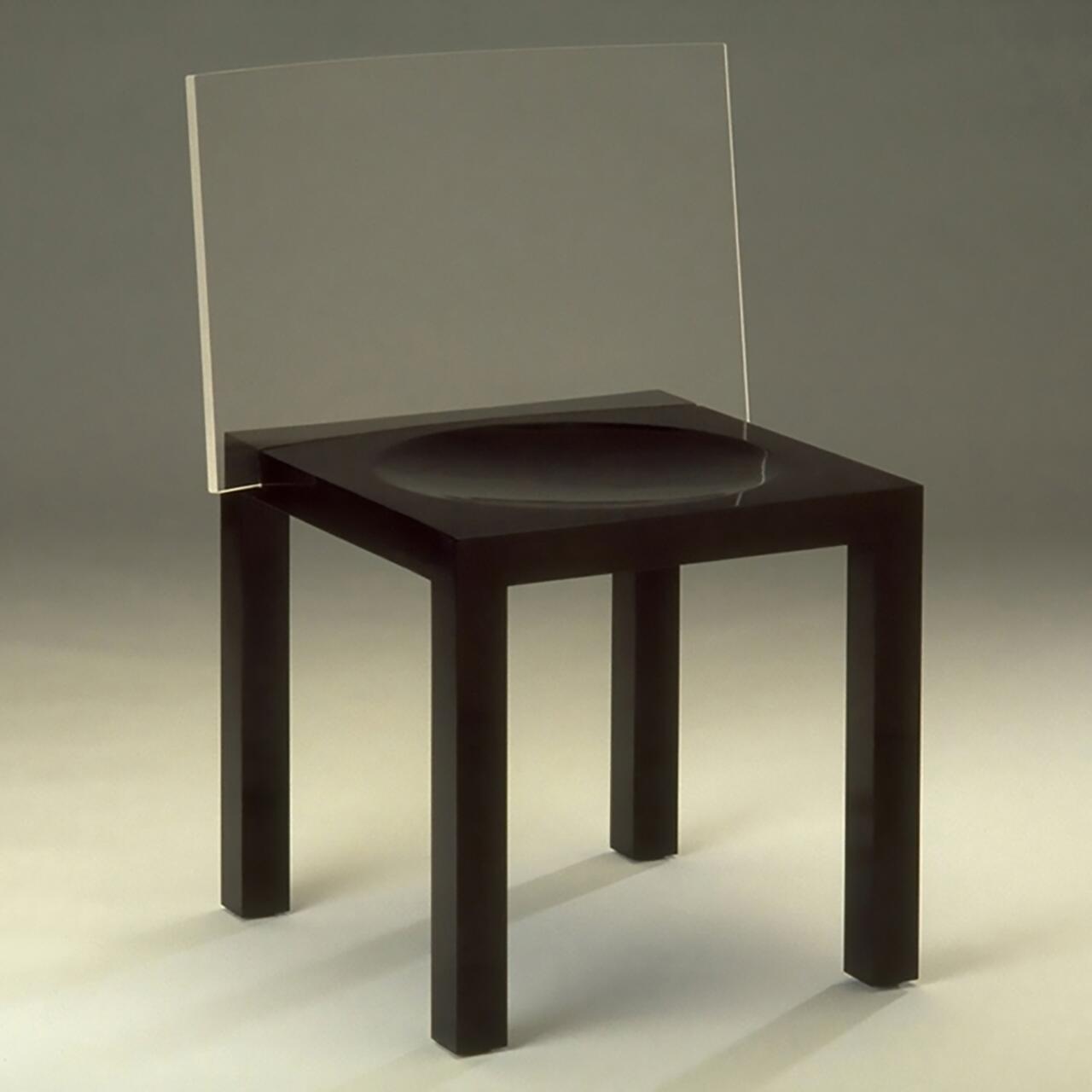 A black chair with a transparent backrest and a curved seat, set against a neutral background.