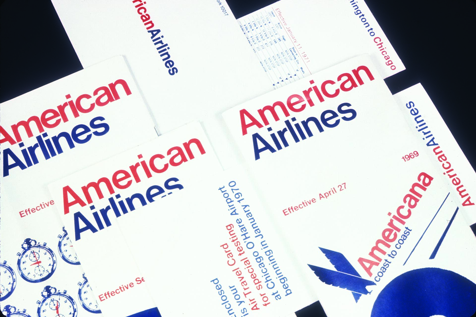 American Airlines brochures featuring bold red and blue text, overlapping each other. Some brochures display clocks or plane graphics. The layout is visually appealing with a focus on the brand's name and travel information.