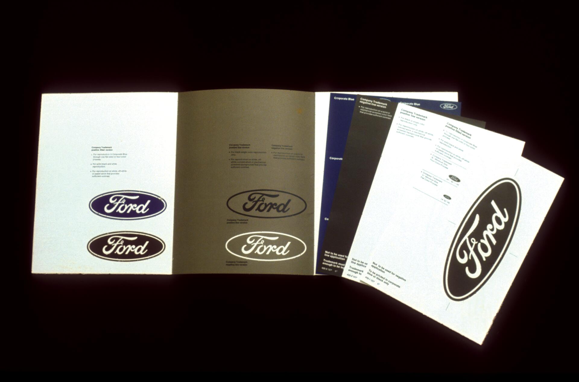 Open booklet displaying multiple Ford logos on each page against a dark background.