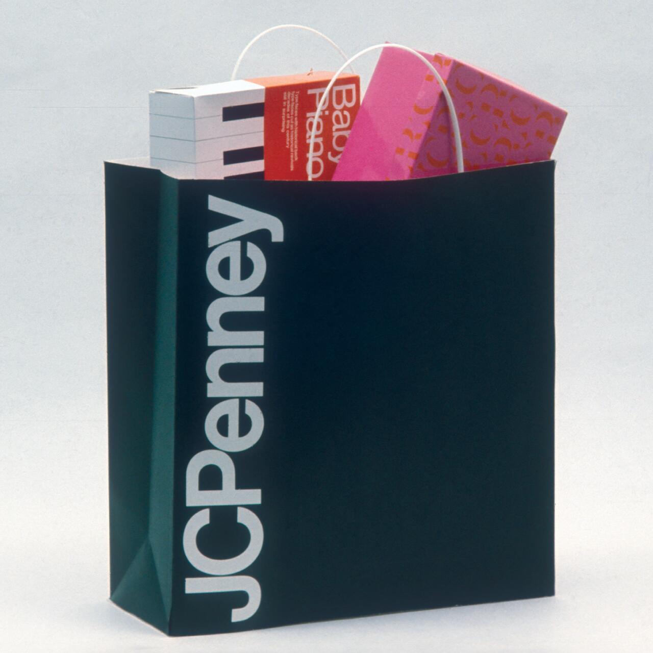 Shopping bag with "JCPenney" logo in white, filled with colorful boxes.
