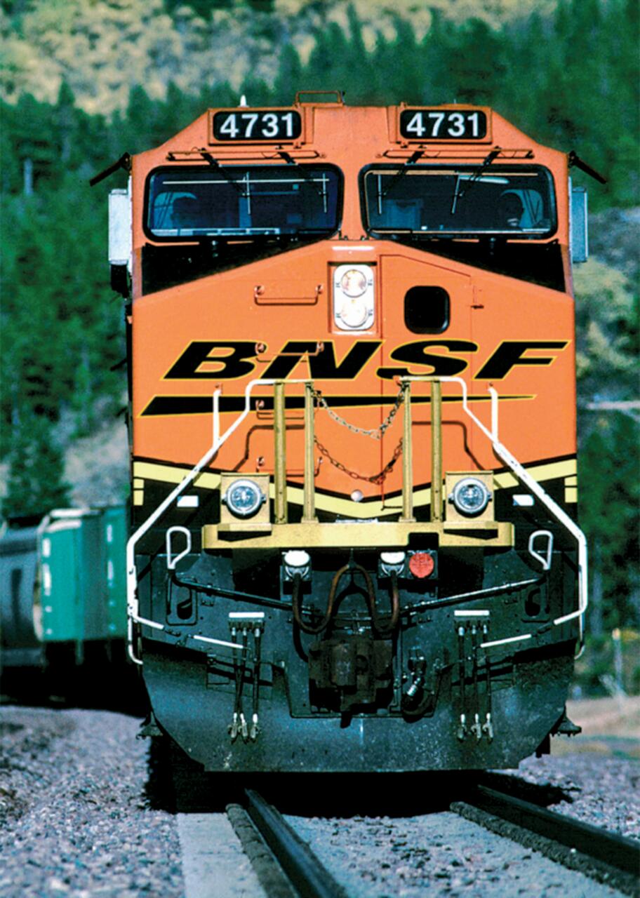 Orange locomotive with number 4731 on front, marked BNSF, on a railway track surrounded by greenery.