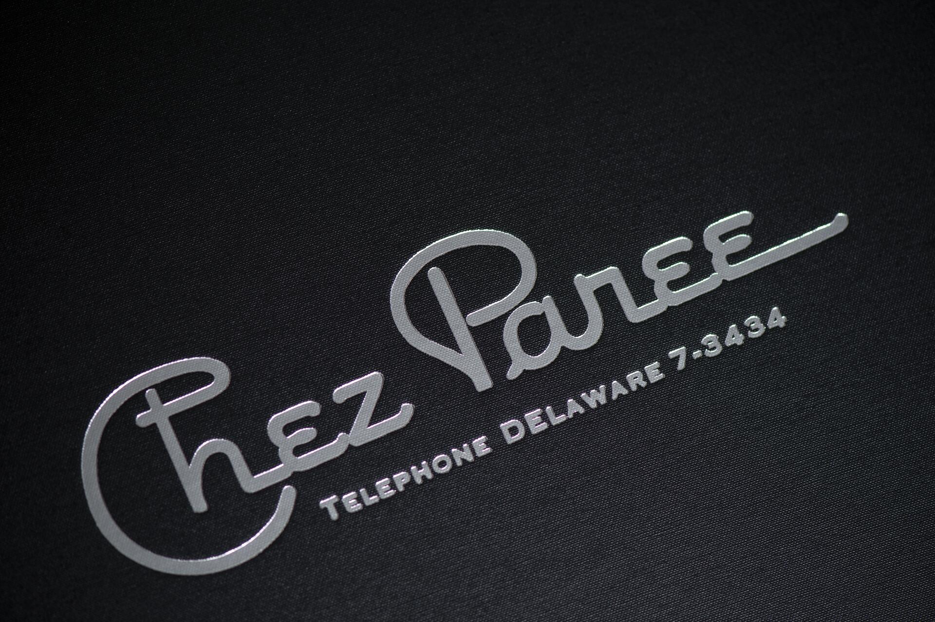 Silver embossed text "Chez Paree" and "Telephone Delaware 7-3434" on a dark background.