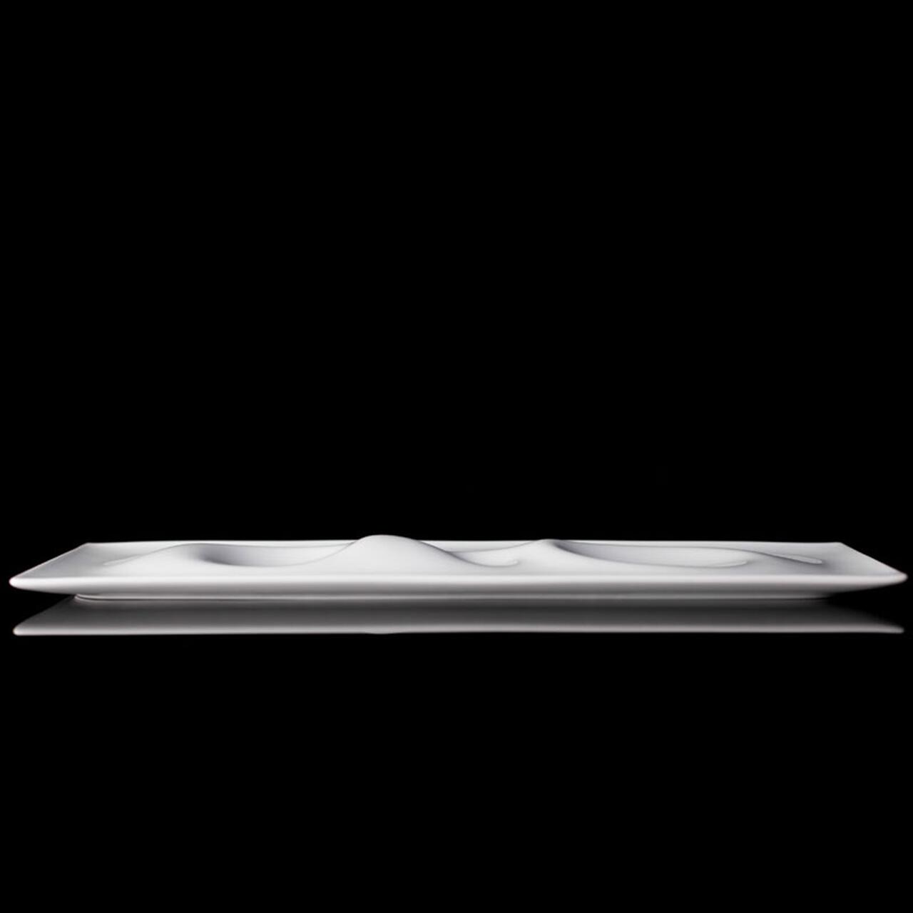 A sleek, white rectangular dish with subtle, wave-like indentations sits against a black background.