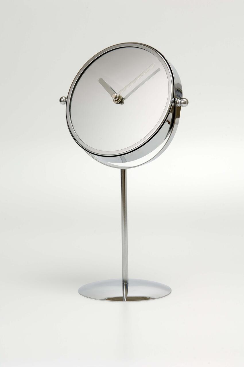 A round, modern tabletop clock with a mirrored face and minimalist hands, mounted on a slim silver stand with a circular base against a plain white background.