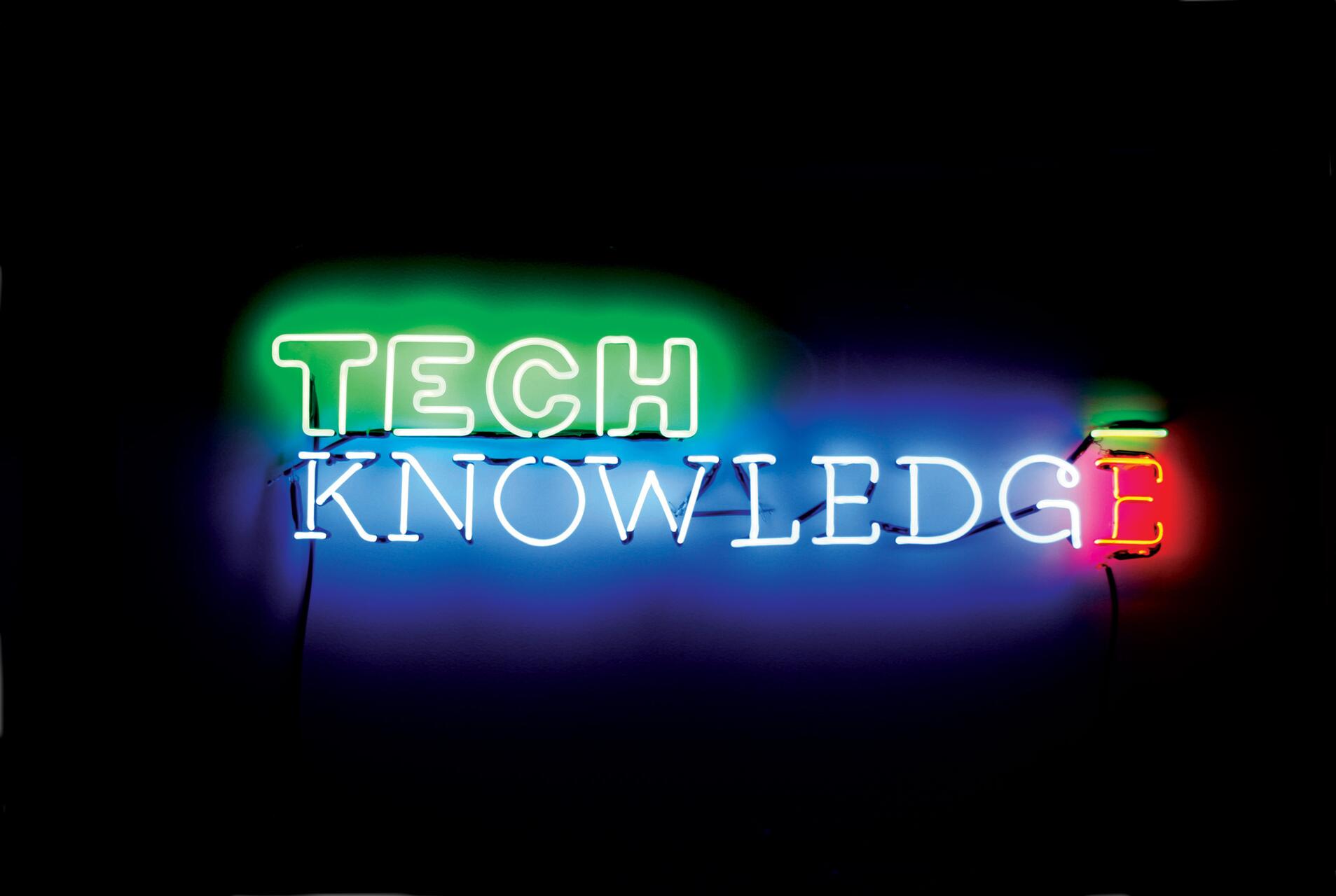 Neon sign reads "TECH KNOWLEDGE" with "TECH" in green, "KNOWLEDGE" in blue, and the final "E" in red and green.