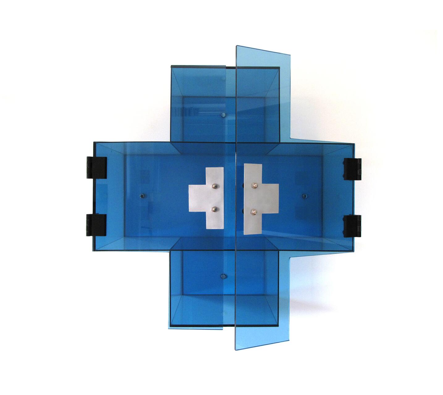 Transparent blue box sculpture with symmetrical geometric design and metal crosses inside.