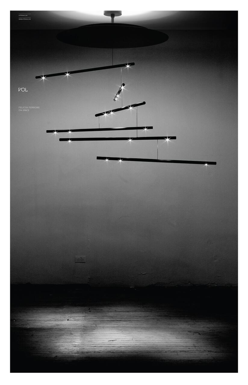 Black and white photograph of a minimalist pendant light fixture with horizontal bars, each illuminated with small glowing bulbs, suspended in mid-air against a dimly lit wall.