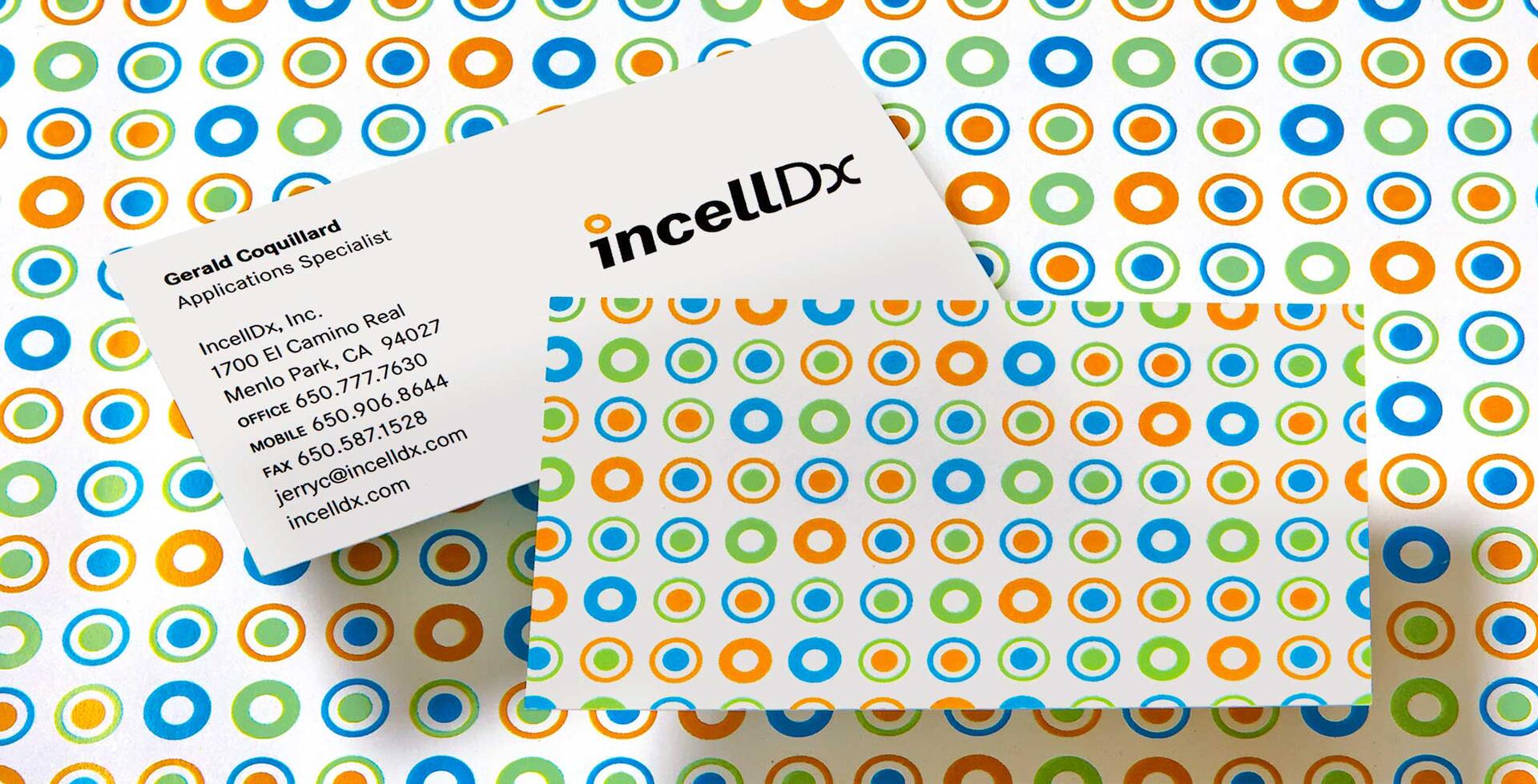 Business card for incellDx with contact details on a colorful background of orange, green, and blue circles.