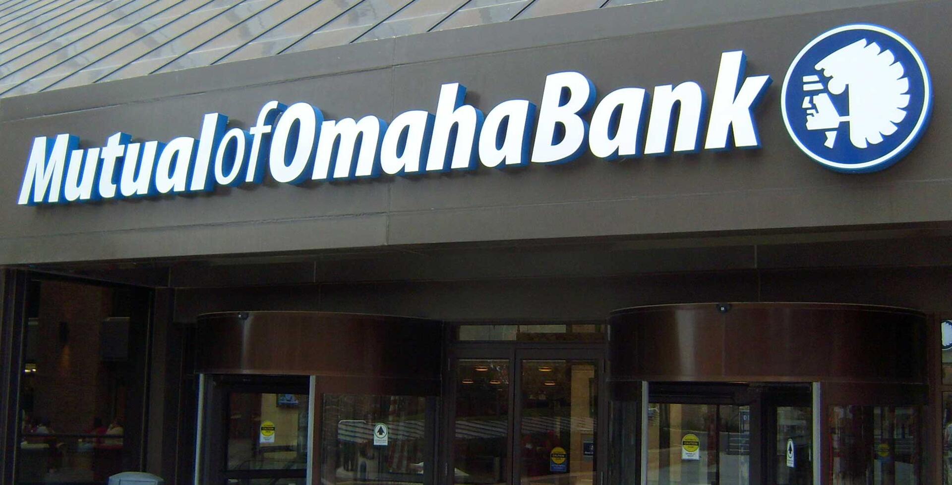 Mutual of Omaha Bank sign on a building facade with a Native American headdress logo.