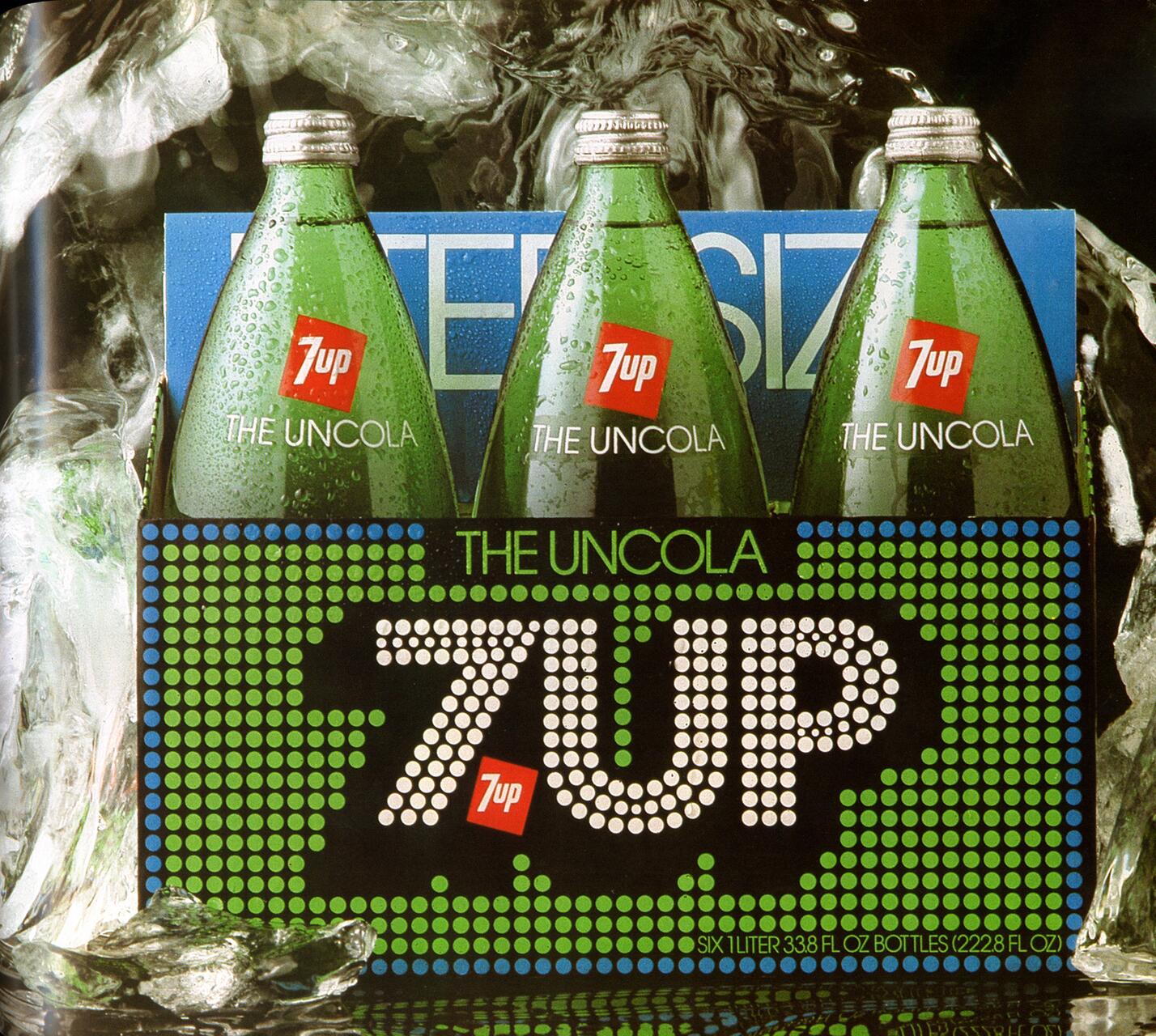 Three 7UP glass bottles in a cardboard carrier labeled "The Uncola" with ice surrounding them.