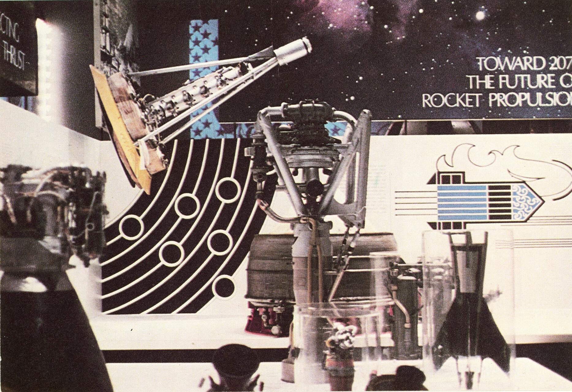 Rocket engine displays in a futuristic exhibit setting with scientific designs and cosmic imagery in the background.