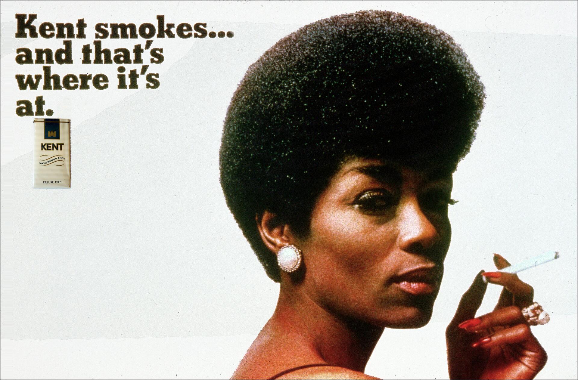 Woman with an afro hairstyle holding a cigarette, wearing earrings and a ring. The background includes a pack of Kent cigarettes and text promoting the brand.