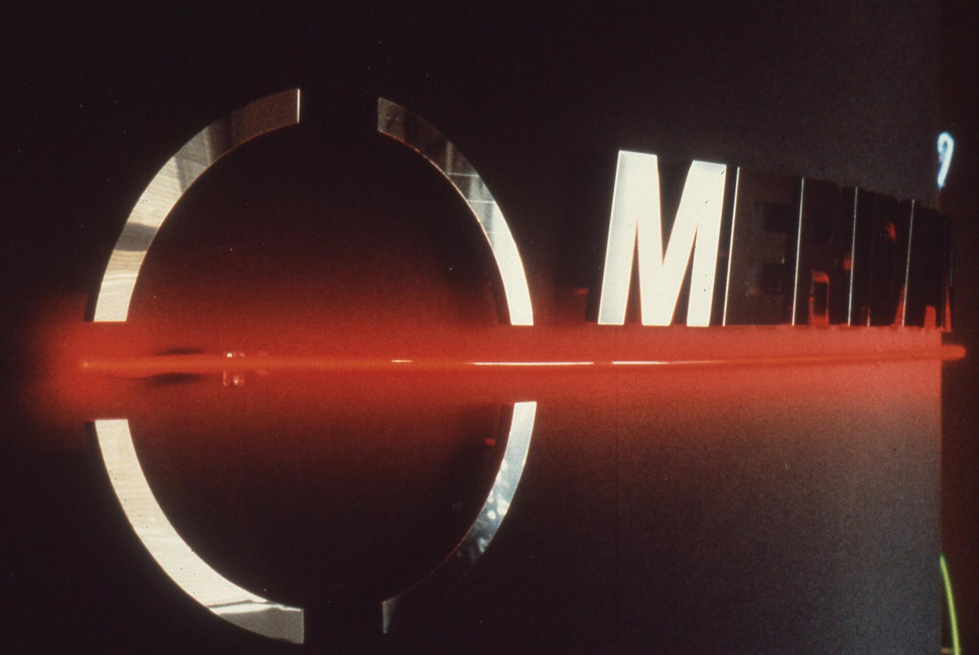Red neon lighting emphasizes chrome letters spelling "MERIDIAN" on a dark background.