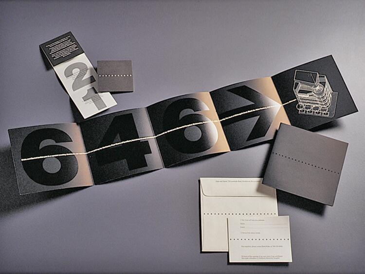 Accordion-style brochure with large, bold numbers and a typewriter graphic. An envelope and small booklet are nearby on a gray surface.