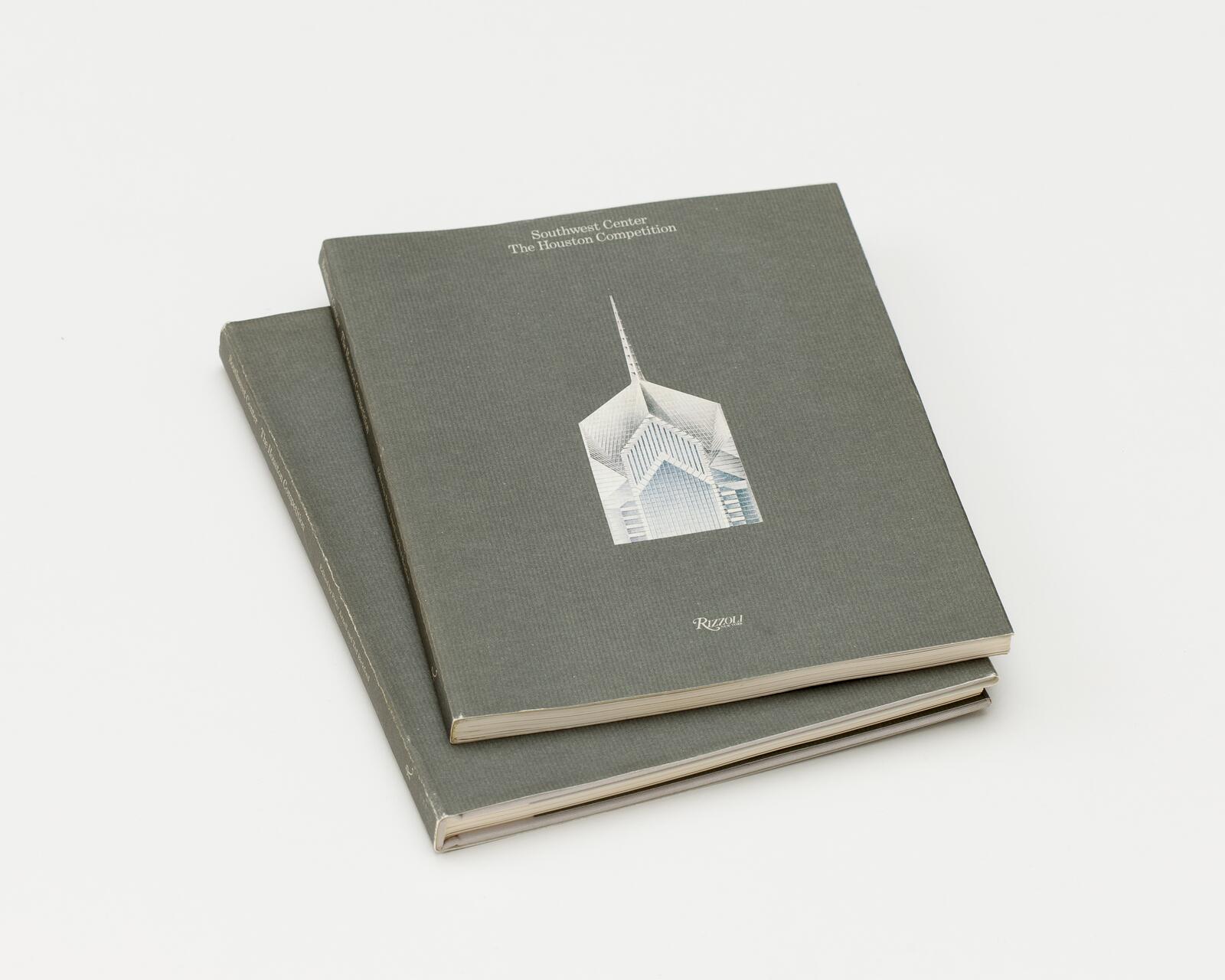 Two gray hardcover books stacked, featuring a stylized skyscraper illustration on the cover.