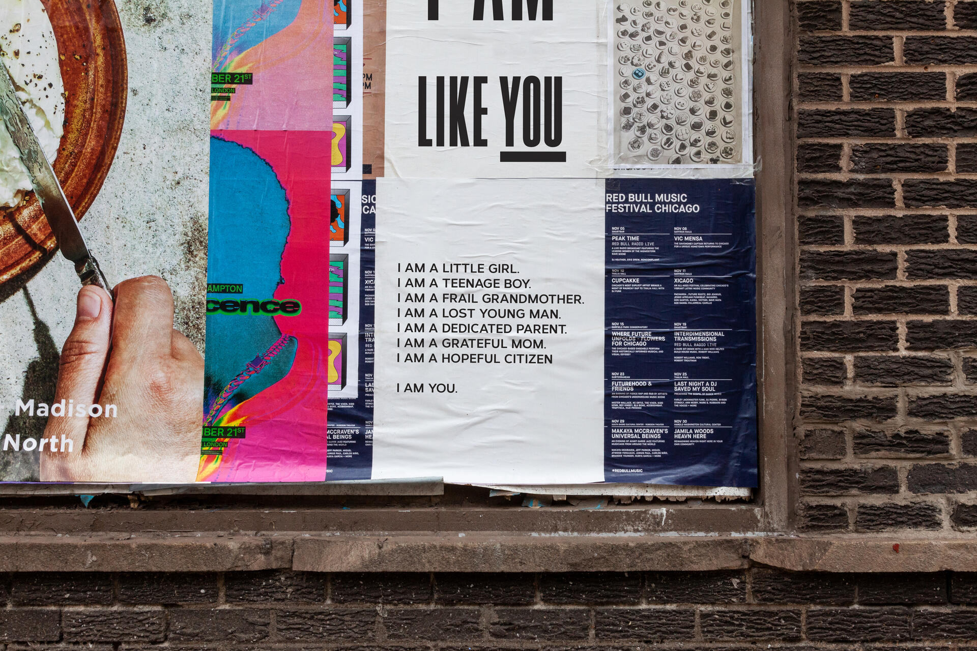 Street posters on a brick wall. Central poster features text stating different identities like "I am a little girl" and "I am a dedicated parent." Neighboring posters are colorful with event details and a close-up of a hand with a knife.