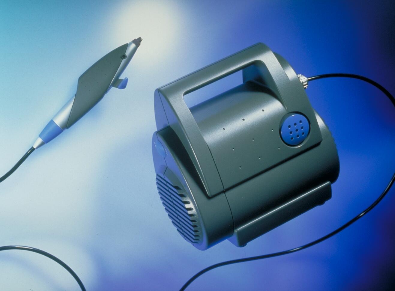 Black dental air-abrasion unit with a connected handpiece, set against a gradient blue background.