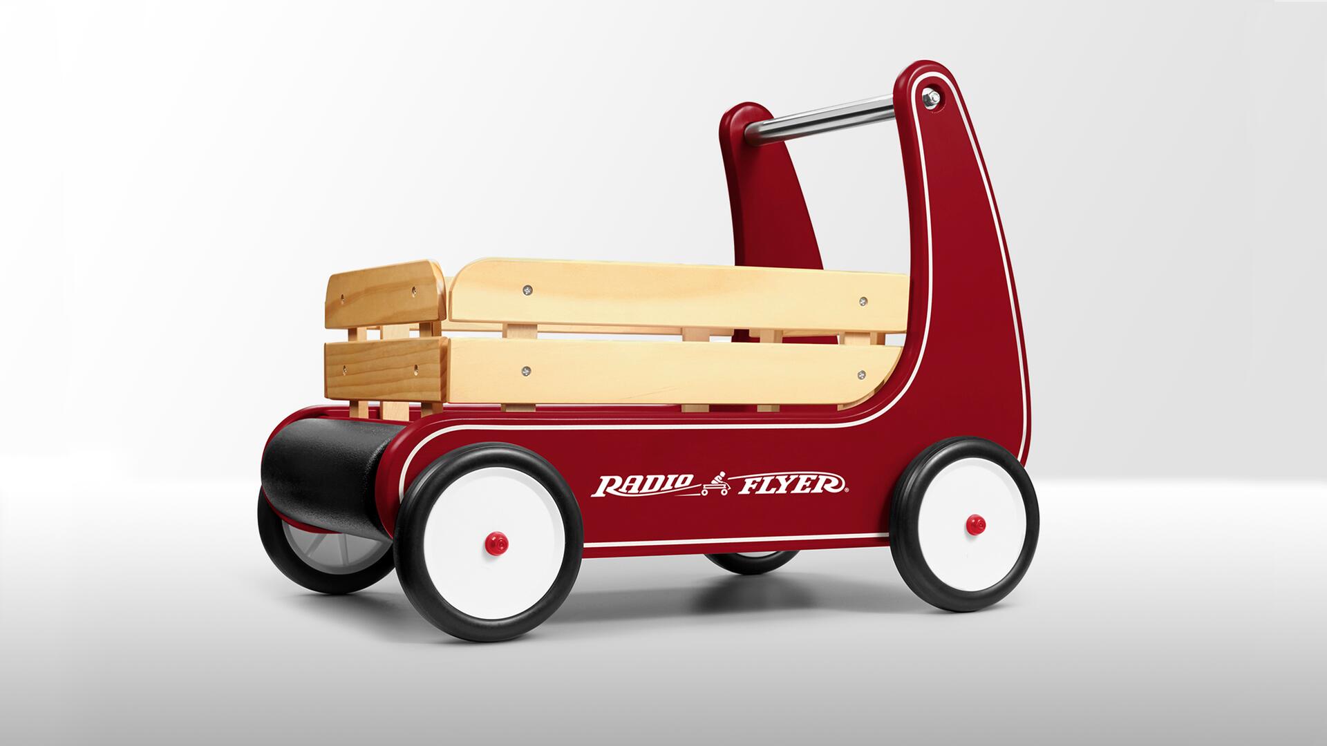 Red and wooden child's wagon with four wheels and a push handle, labeled "Radio Flyer" on the side.