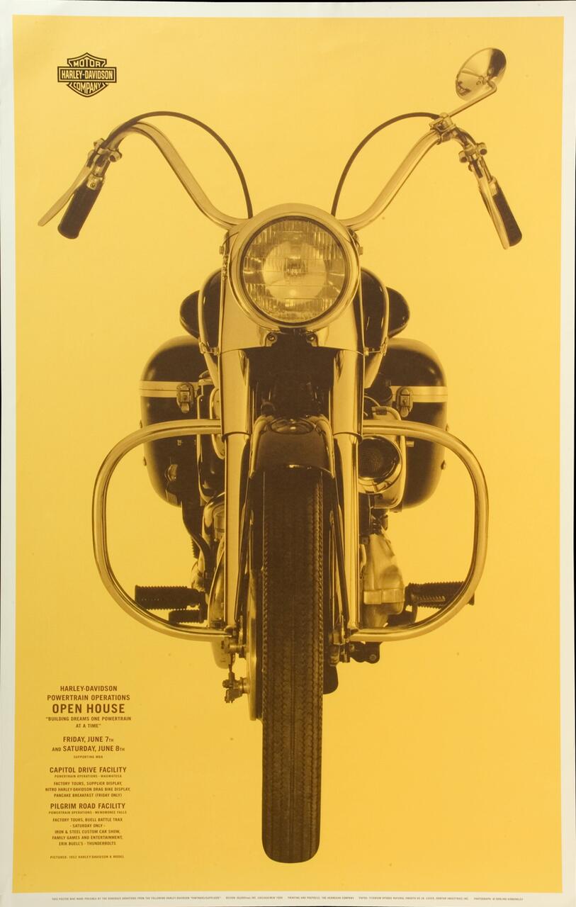 Front view of a Harley-Davidson motorcycle on a yellow background, featuring wide handlebars, round headlight, and the company logo at the top left.