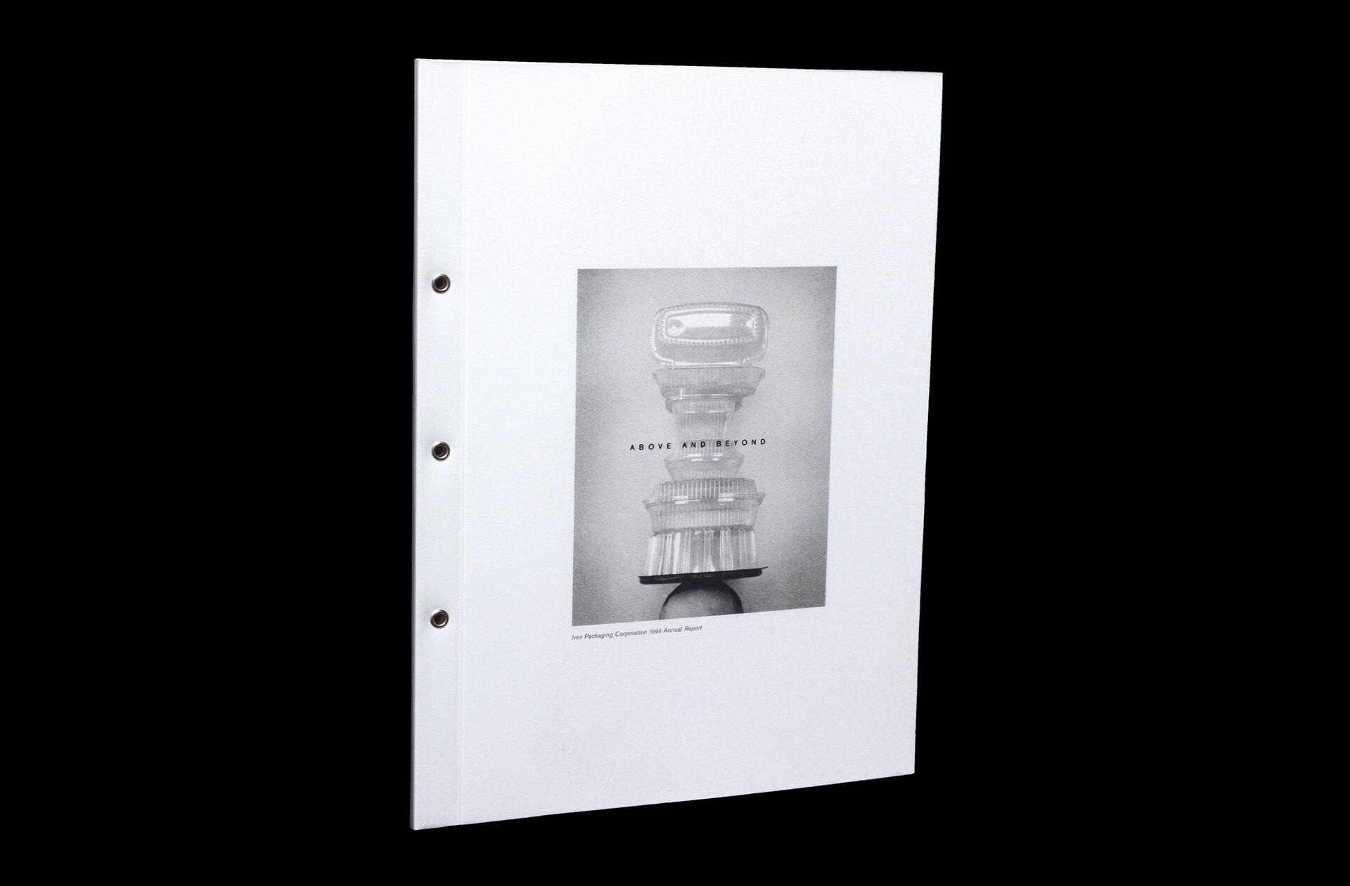 White booklet cover featuring a grayscale image of stacked objects resembling glassware, with the text "ABOVE AND BEYOND."