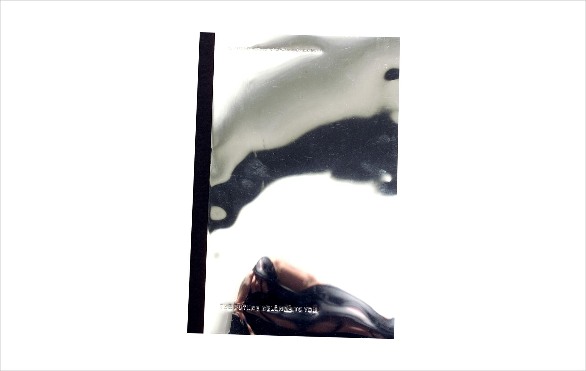 Shiny, silver-plated book cover with dark abstract shapes and a black spine.