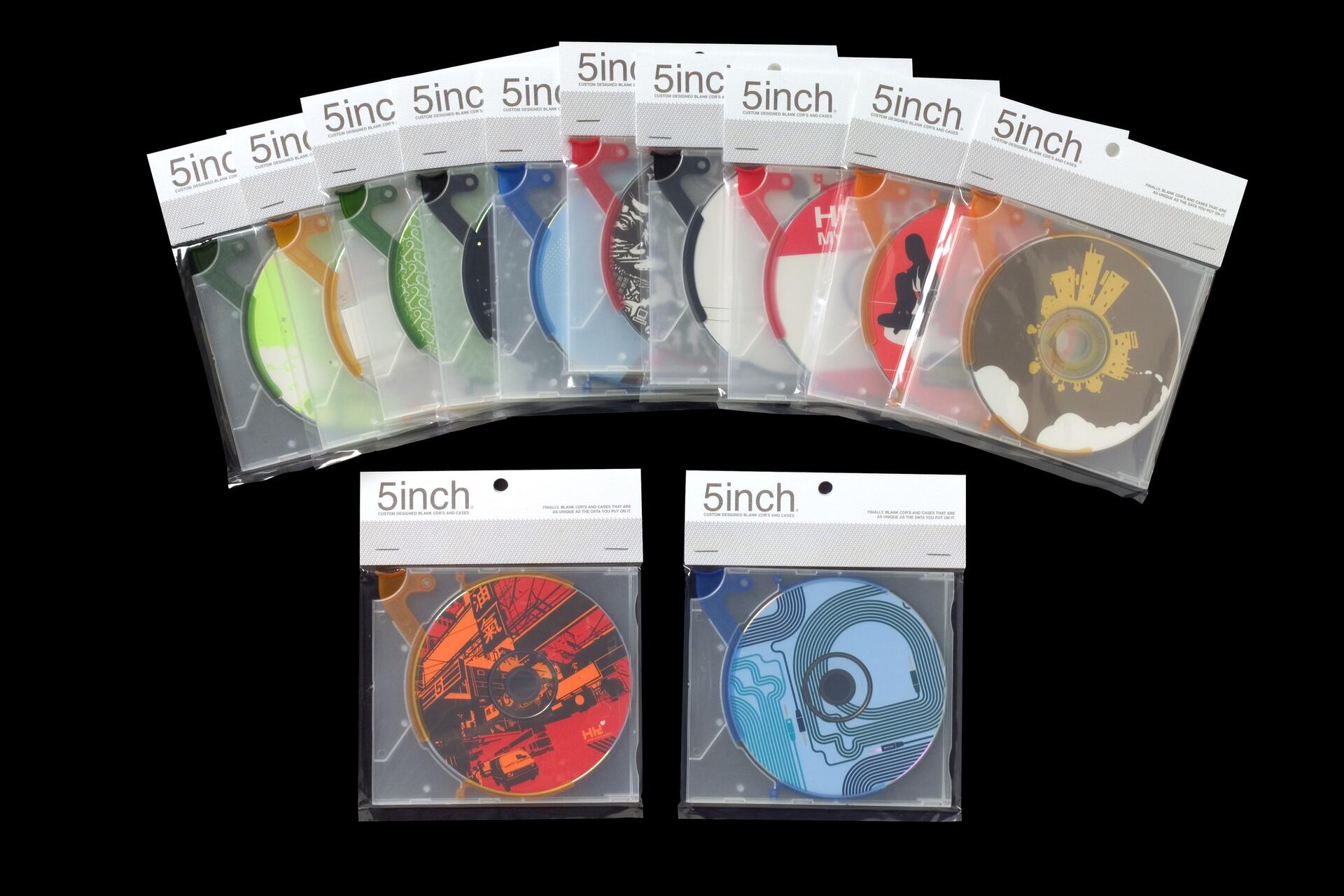 A collection of 10 colorful, graphically designed CDs in transparent packaging, labeled "5inch," arranged in an arc. Below, two extra CDs with artistic motifs, one red with urban graphics and one blue with abstract lines. Black background.