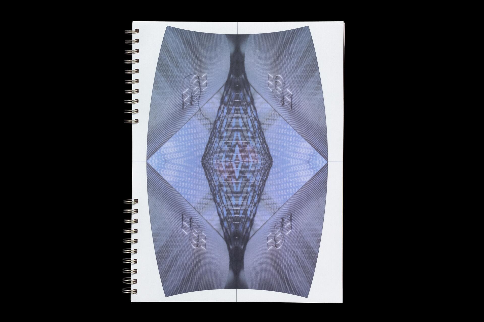 Abstract design on a spiral-bound notebook, featuring a mirrored geometric pattern with blue and gray hues.