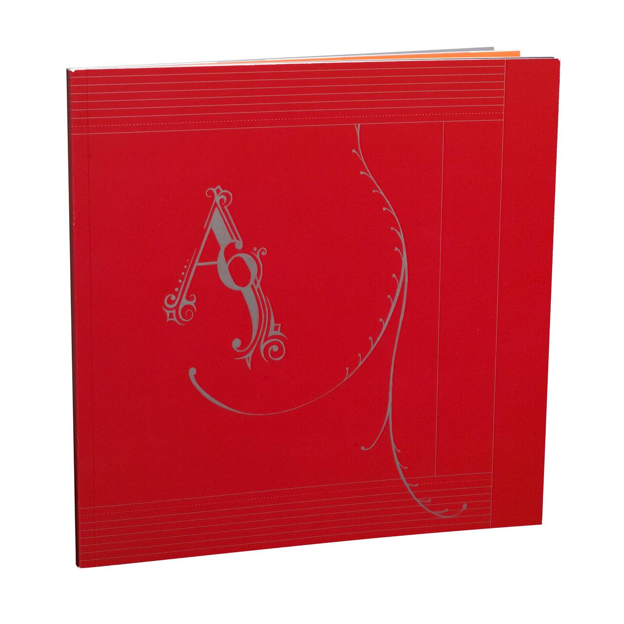 Red book cover with intricate silver embellishment forming the letter "A" and the number "9," featuring decorative swirls and lines.