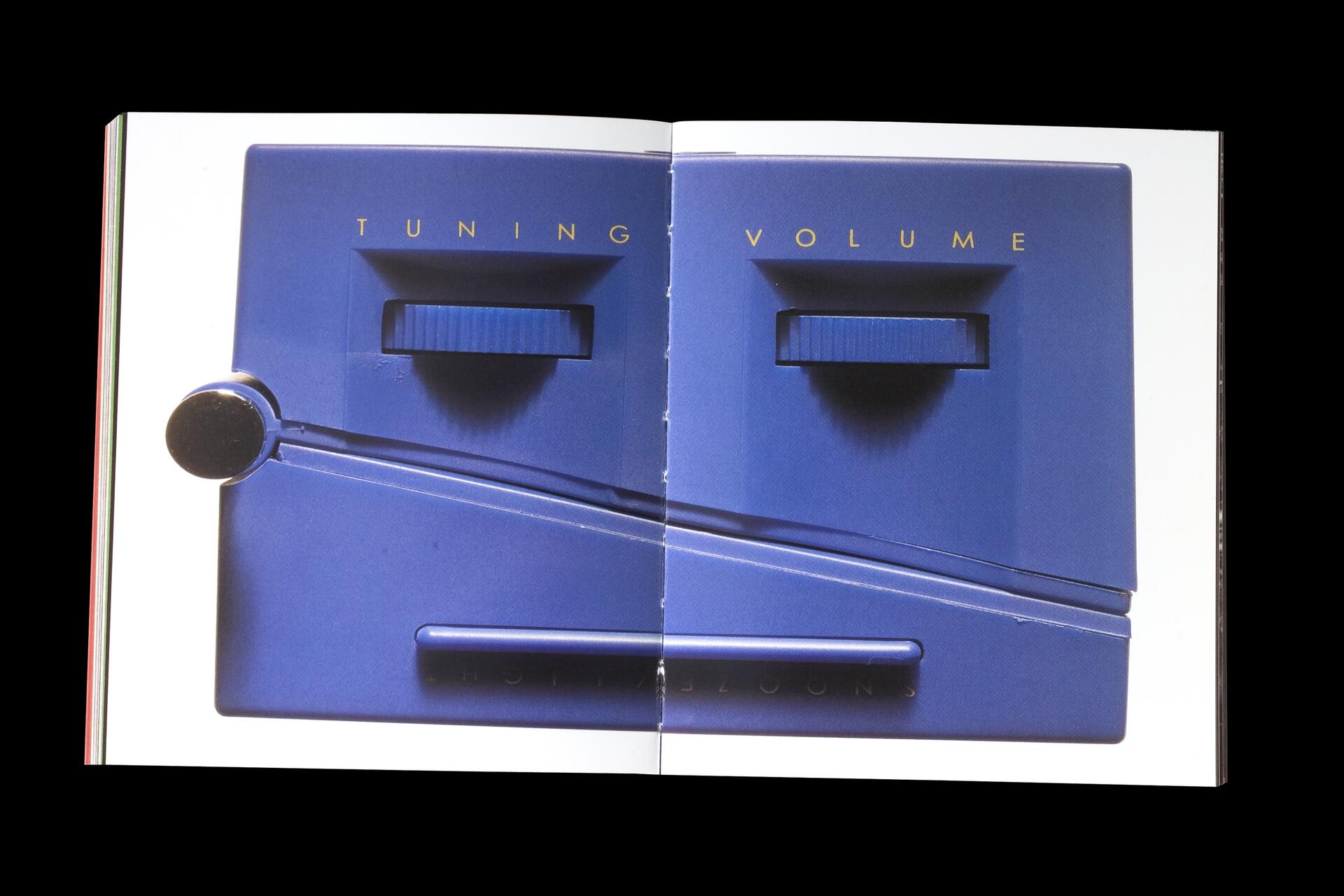 Blue stereo controls with knobs for tuning and volume, featured on an open page of a book.