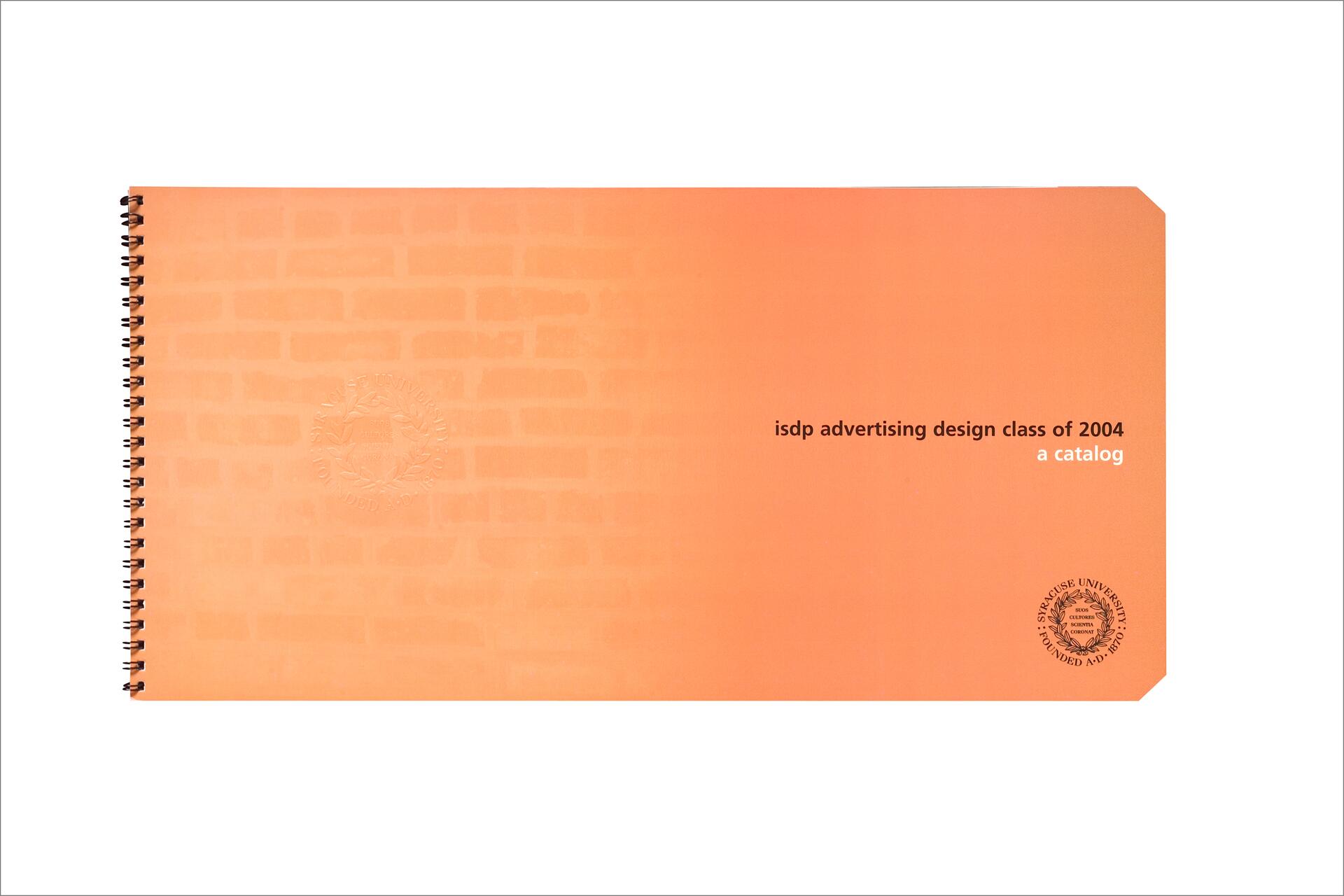 Orange catalog with "isdp advertising design class of 2004" in black text, featuring a spiral binding on the left. Subtle brick pattern and two embossed university seals are visible.