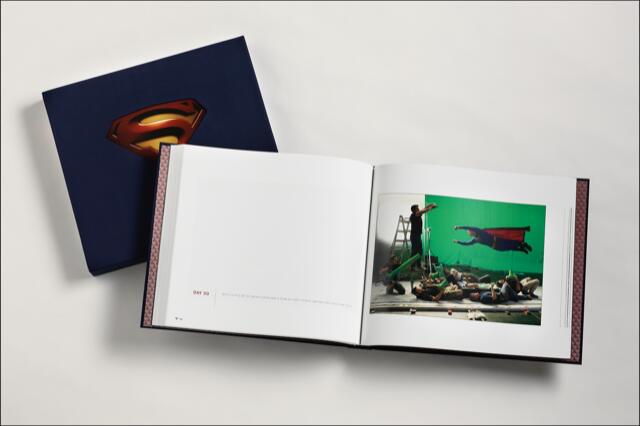 Open book showing a movie set with a person in a Superman costume suspended in front of a green screen. Another book rests beside it, featuring a Superman logo on the cover.