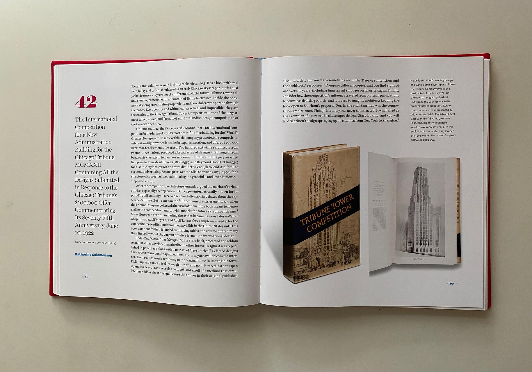 Open book displaying a text about the International Competition for a New Administration Building for the Chicago Tribune. Includes an image of the competition book with "TRIBUNE TOWER COMPETITION" on the cover, and a black and white image of a skyscraper.