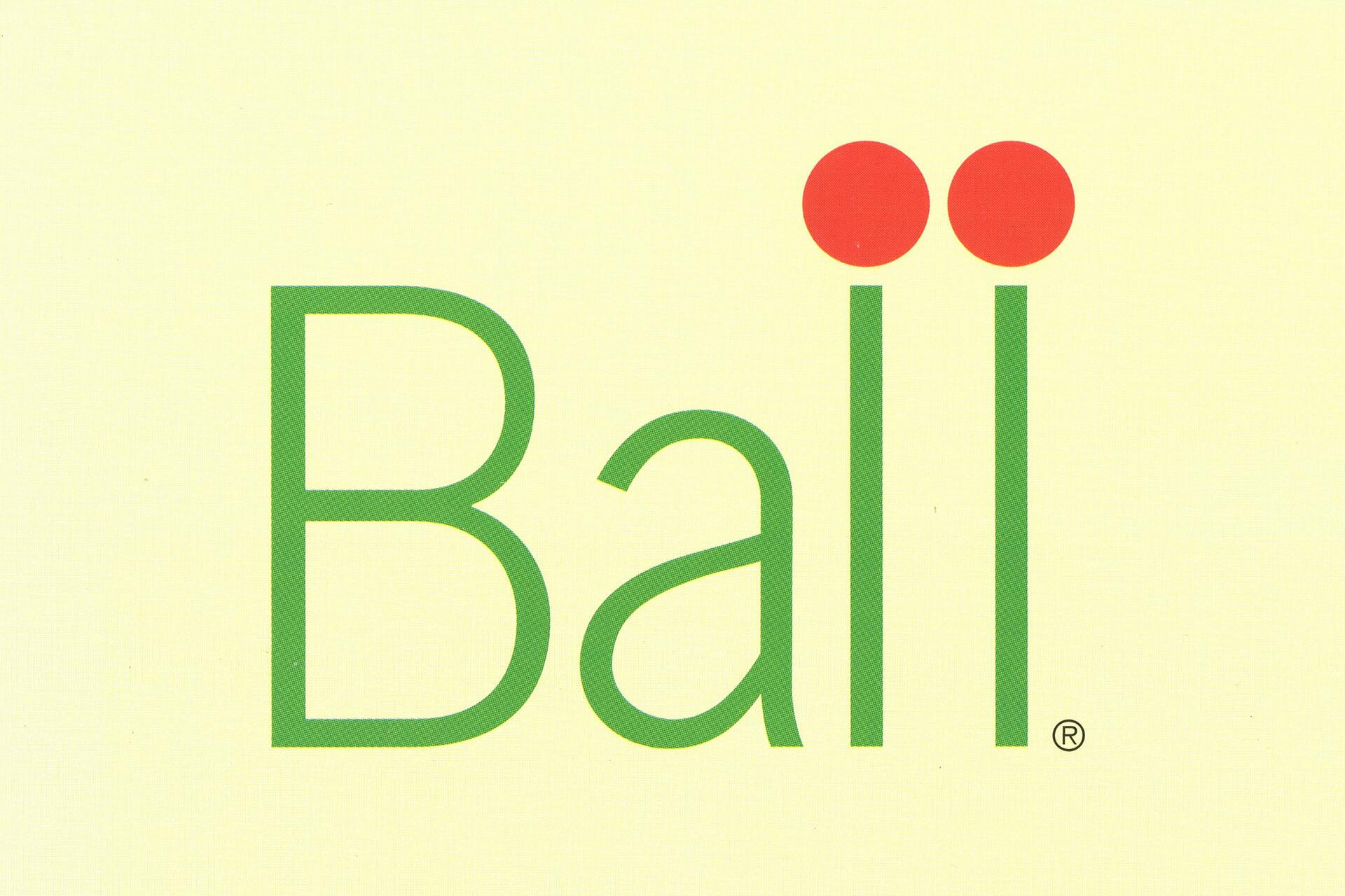 Bali logo with green text on a light yellow background, featuring two red circles above the "i".
