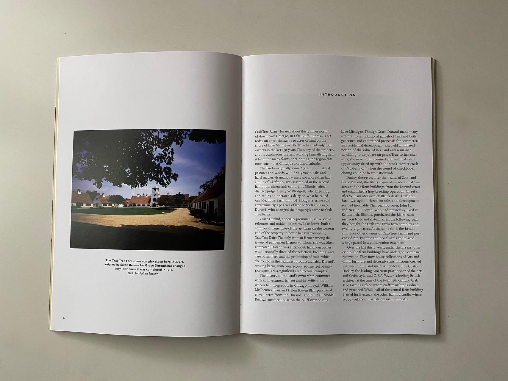 Open book displaying a photograph of a barn complex under a clear sky on the left page and a block of text under the heading "INTRODUCTION" on the right page.