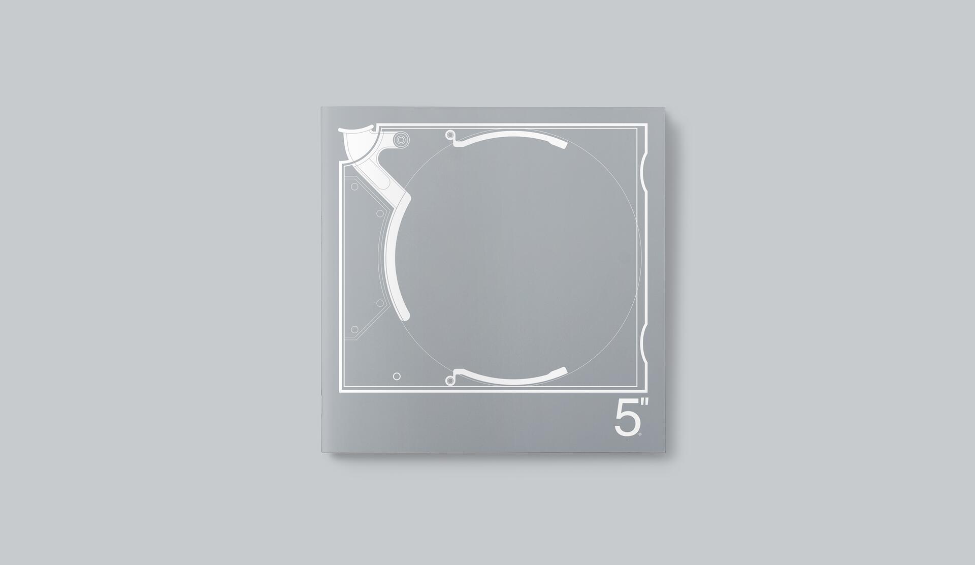 Gray graphic design with white technical drawing lines forming a mechanical circular shape, labeled "5 inches" on the bottom corner.