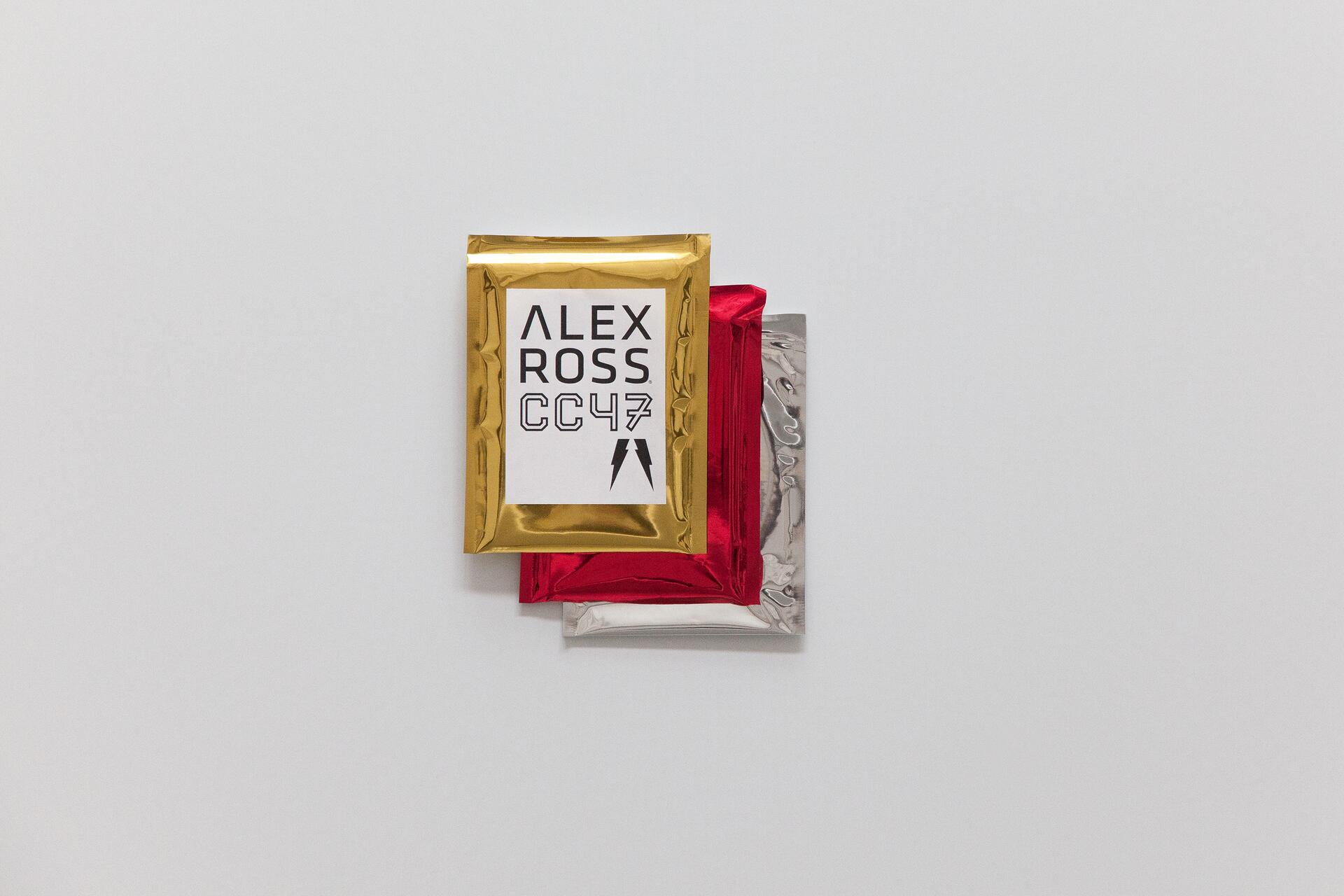 Gold, red, and silver foil packages stacked on a white background, with text "ALEX ROSS CC47" on the top package.