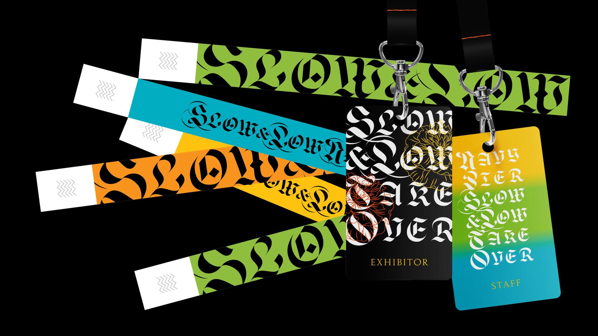 Colorful event wristbands and lanyards with elaborate gothic text on a black background. Various colors include green, blue, and orange. Two lanyards have black and gradient cards attached, labeled "Exhibitor" and "Staff."