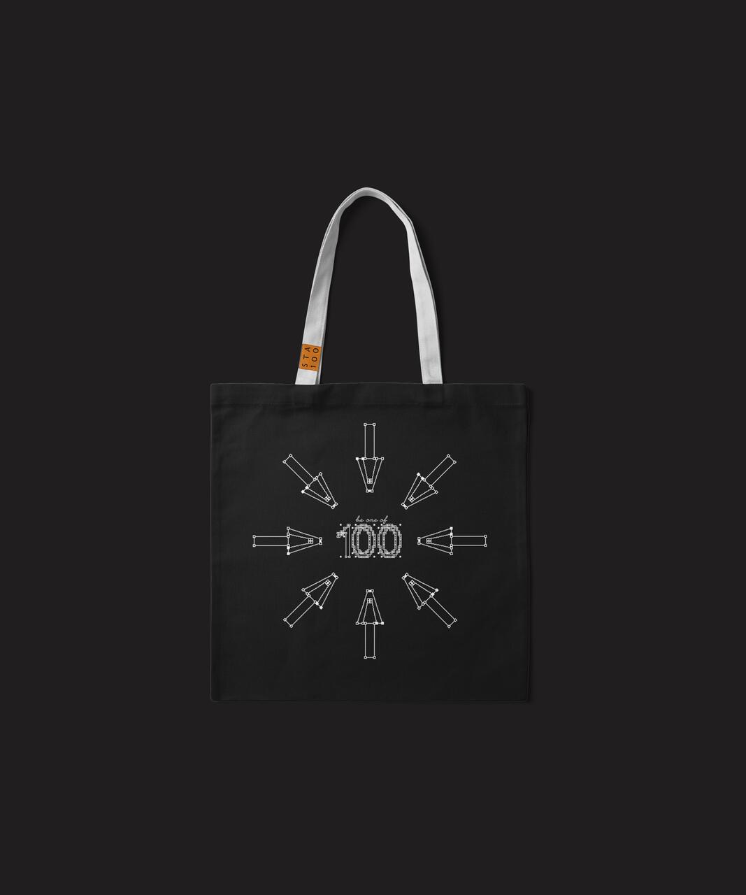 Black tote bag with white handles, featuring a graphic of arrows pointing at "100" in the center.