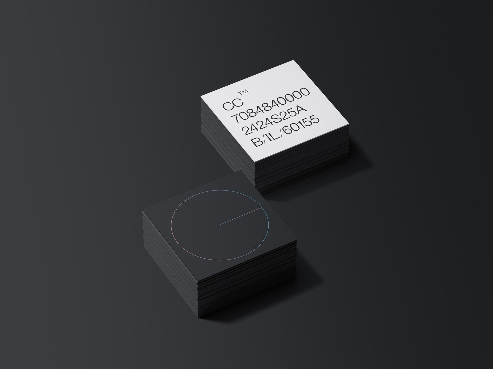 Two stacks of square cards on a dark surface. The stack on the left has cards with a minimalist circle design, while the one on the right has white cards with text and numbers.