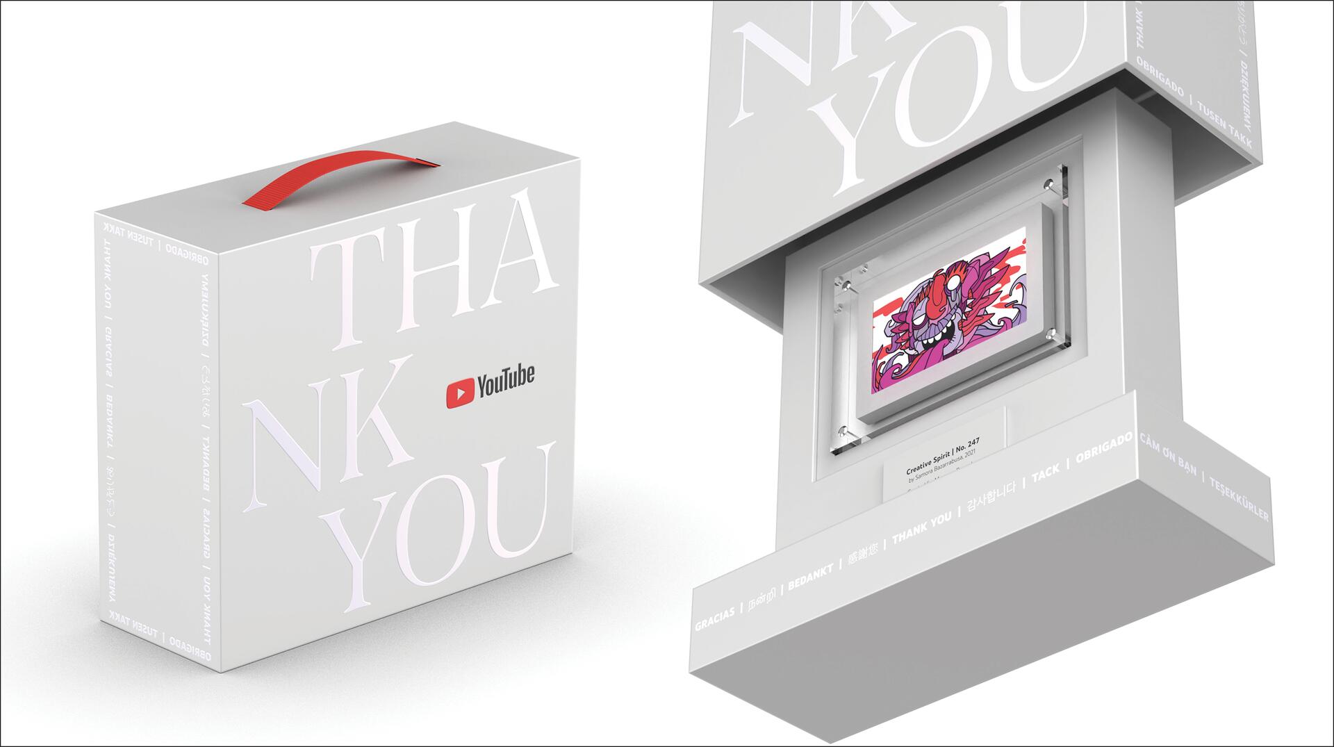 Gray YouTube award box with "THANK YOU" text and red handle, partially opened to reveal a colorful illustration inside labeled as "Creative Spirit No. 247."