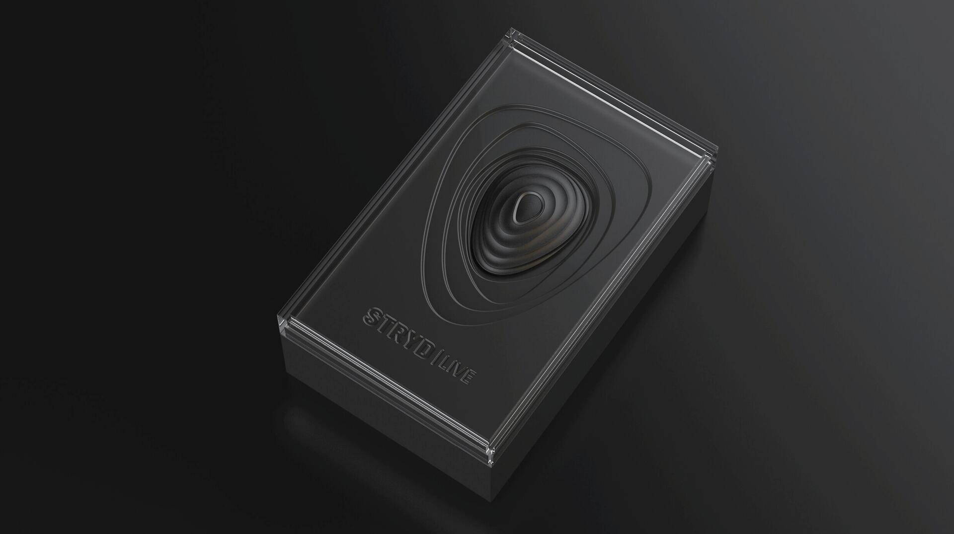 Black rectangular box with an embossed ripple pattern on top, placed against a dark background.